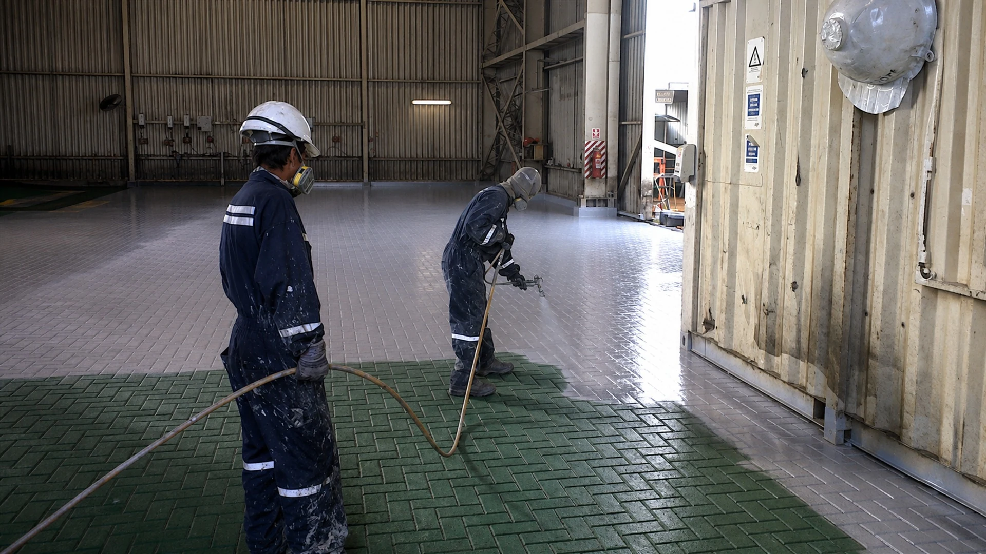Cuadrilla aplicando un revestimiento sobre un piso industrial